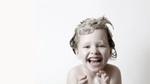 An image of a small child enjoying their bath bubbles, representing the Boots, Unilever and Hygiene Bank campaign