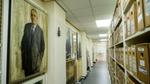 Archive corridor lined with labeled storage boxes and framed portraits