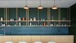 Modern office kitchen with open shelving, decorative ceramics and three pendant lights.