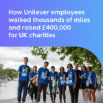 Group of Unilever employees in blue charity walk T-shirts smiling together beside a riverside path