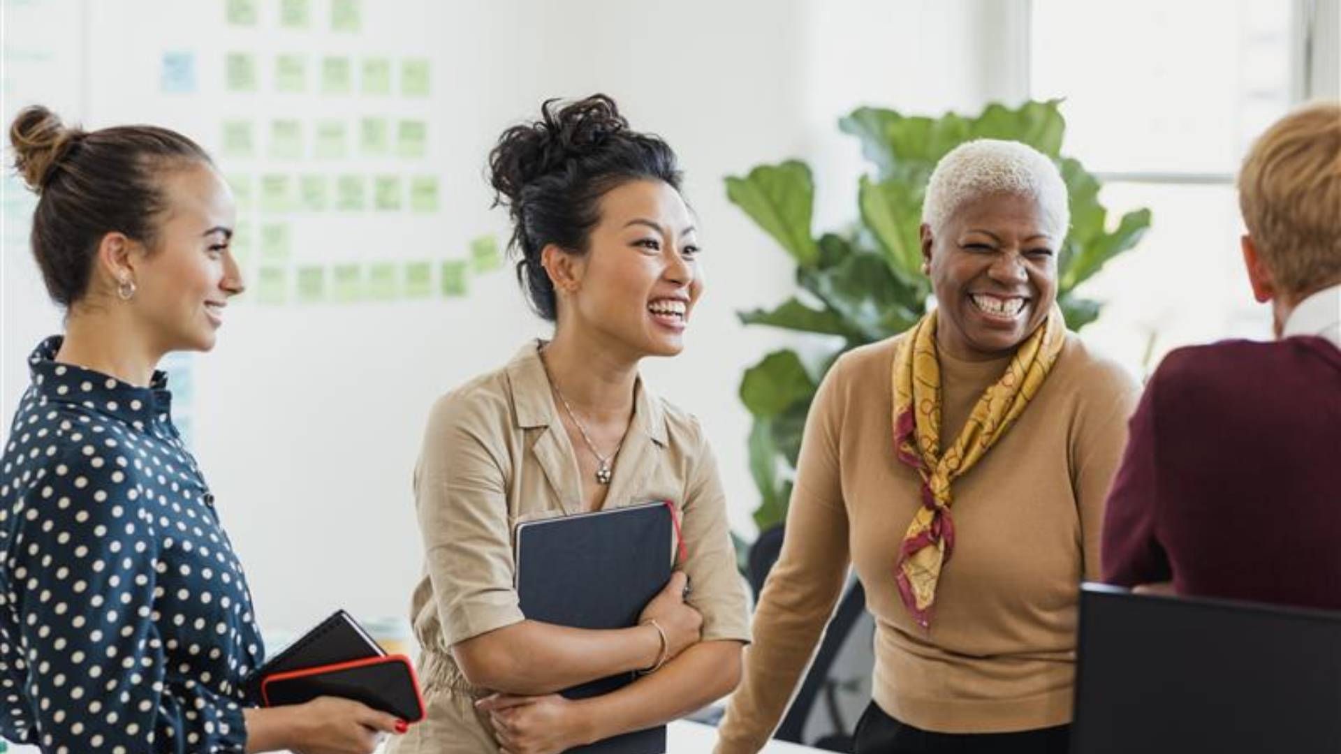 Group of people smiling and talking in an office