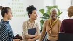 Group of people smiling and talking in an office