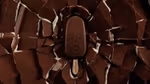 A Magnum ice cream falling into cracking chocolate
