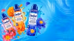 Three Comfort Fresh Scent Booster Elixir bottles with flowers and splashes on a blue background