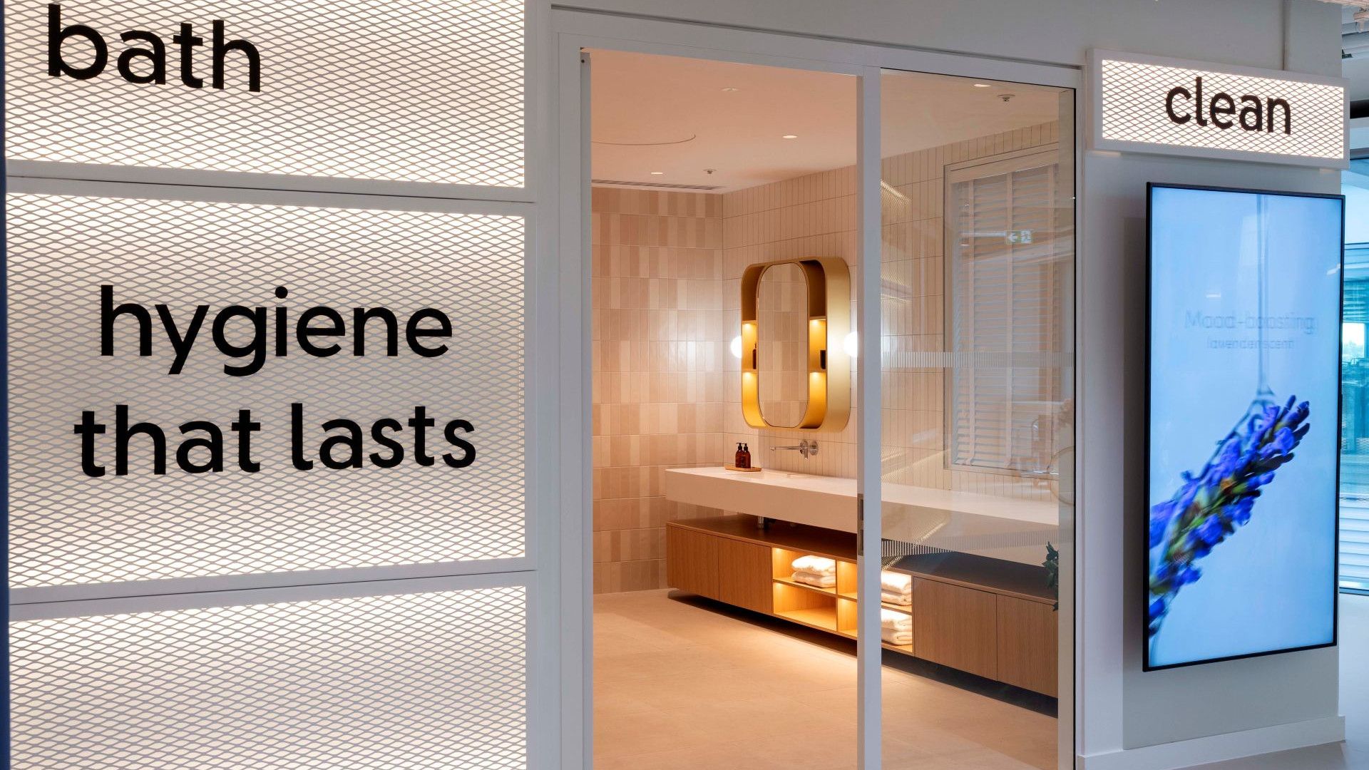 Modern bathroom showroom display with illuminated bath and hygiene signage