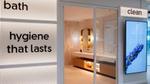 Modern bathroom showroom display with illuminated bath and hygiene signage