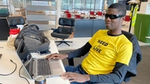 Blind placement student Ademola sat at his desk on his laptop