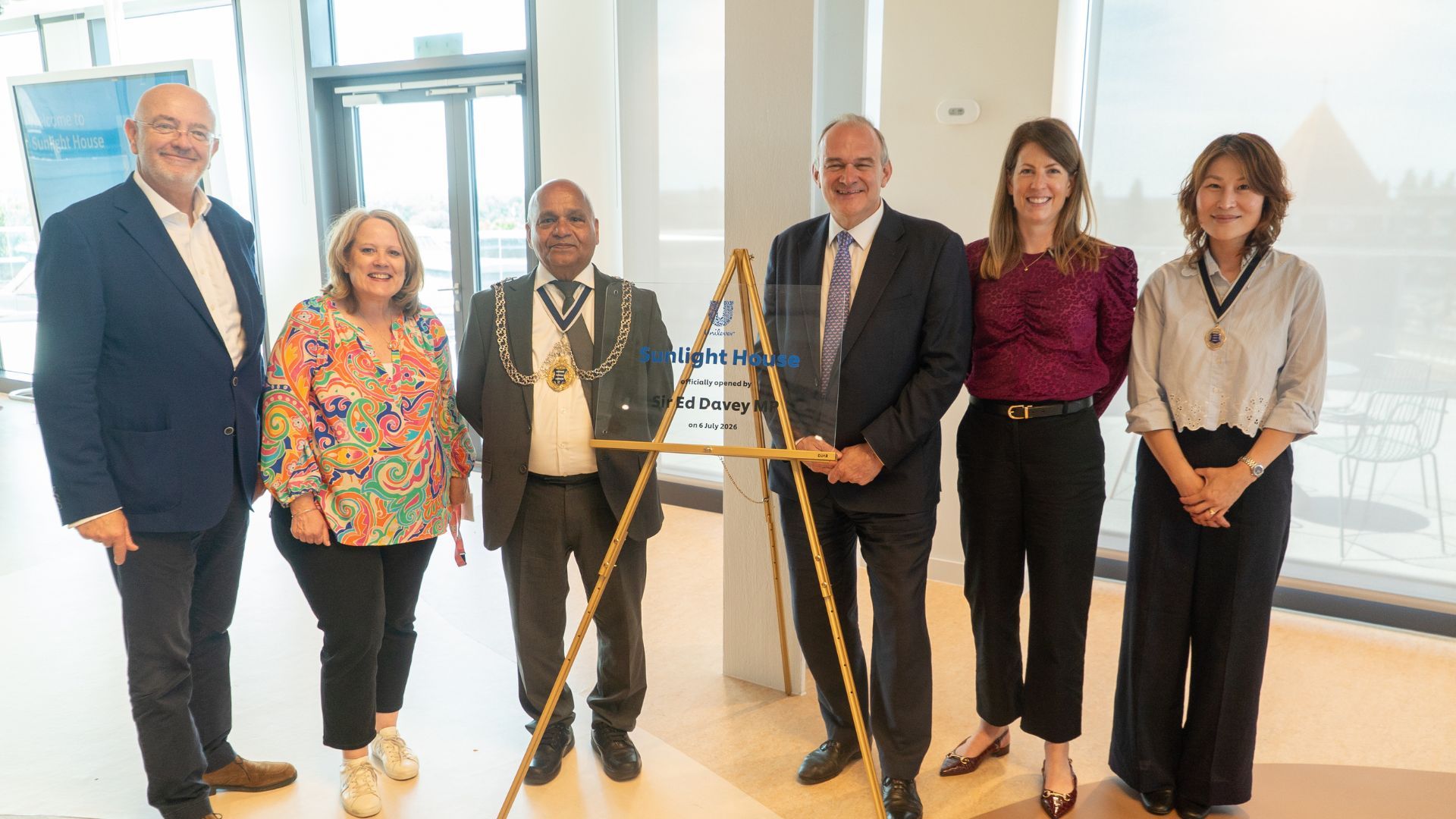 Group of attendees standing beside a commemorative plaque marking the opening of Sunlight House, Unilever's new UK and Ireland headquarters in Kingston upon Thames.