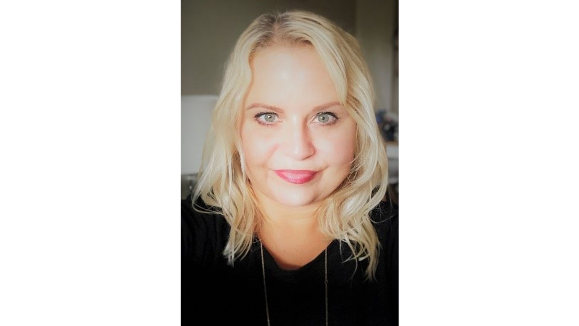 Lucy smiling at camera wearing a black jumper