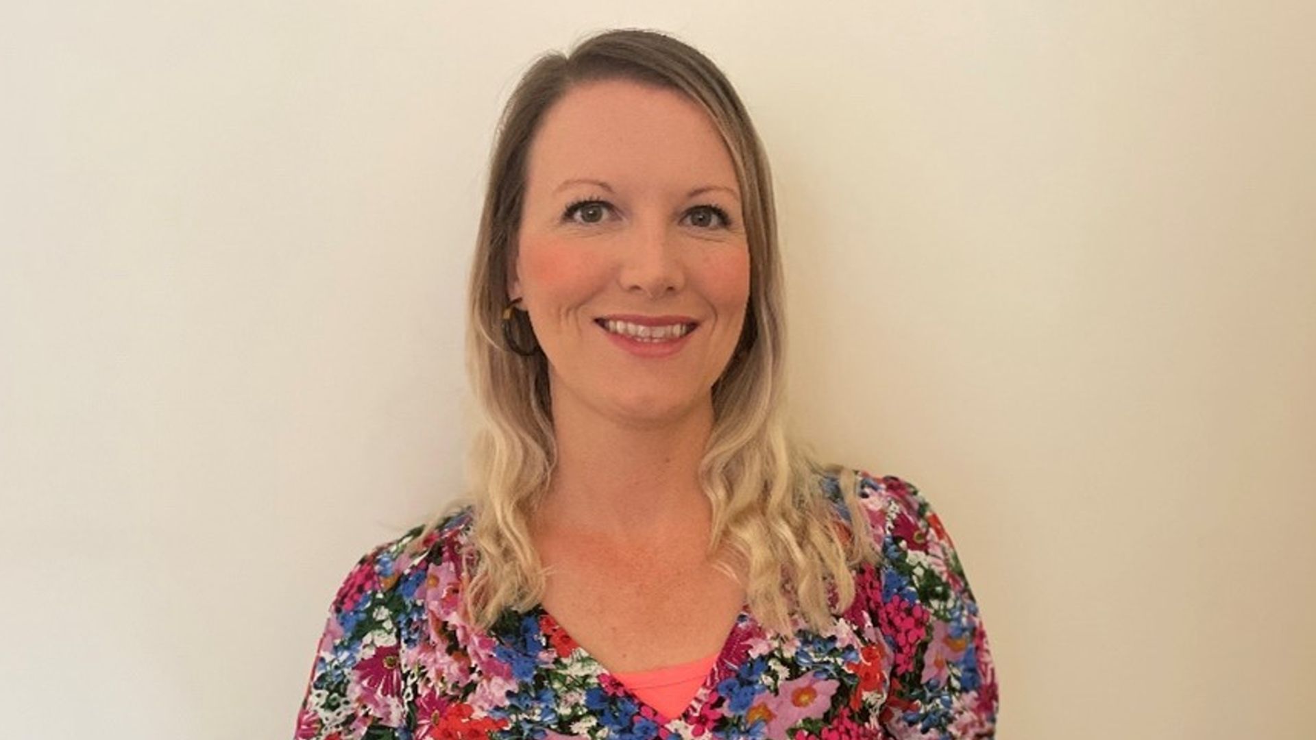 Anna Taylor smiling in a flower dress