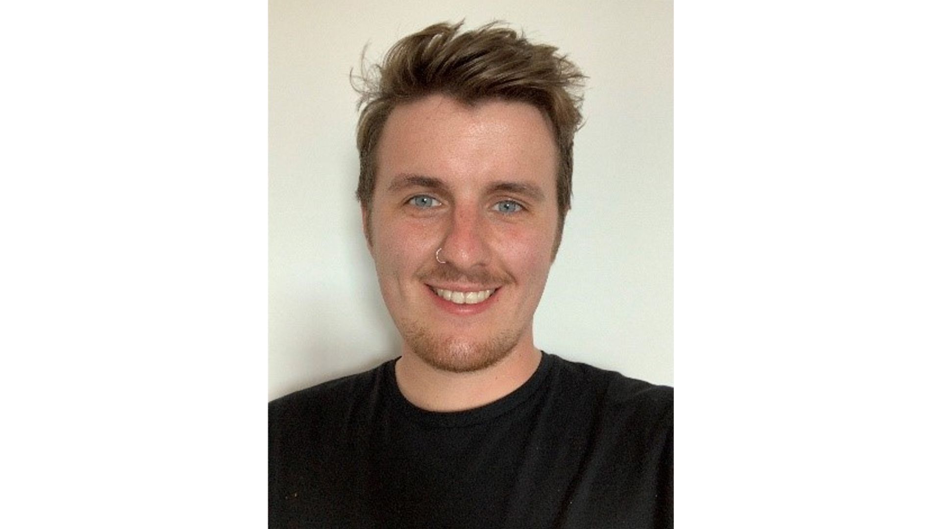 Austin smiling at camera wearing a black t-shirt