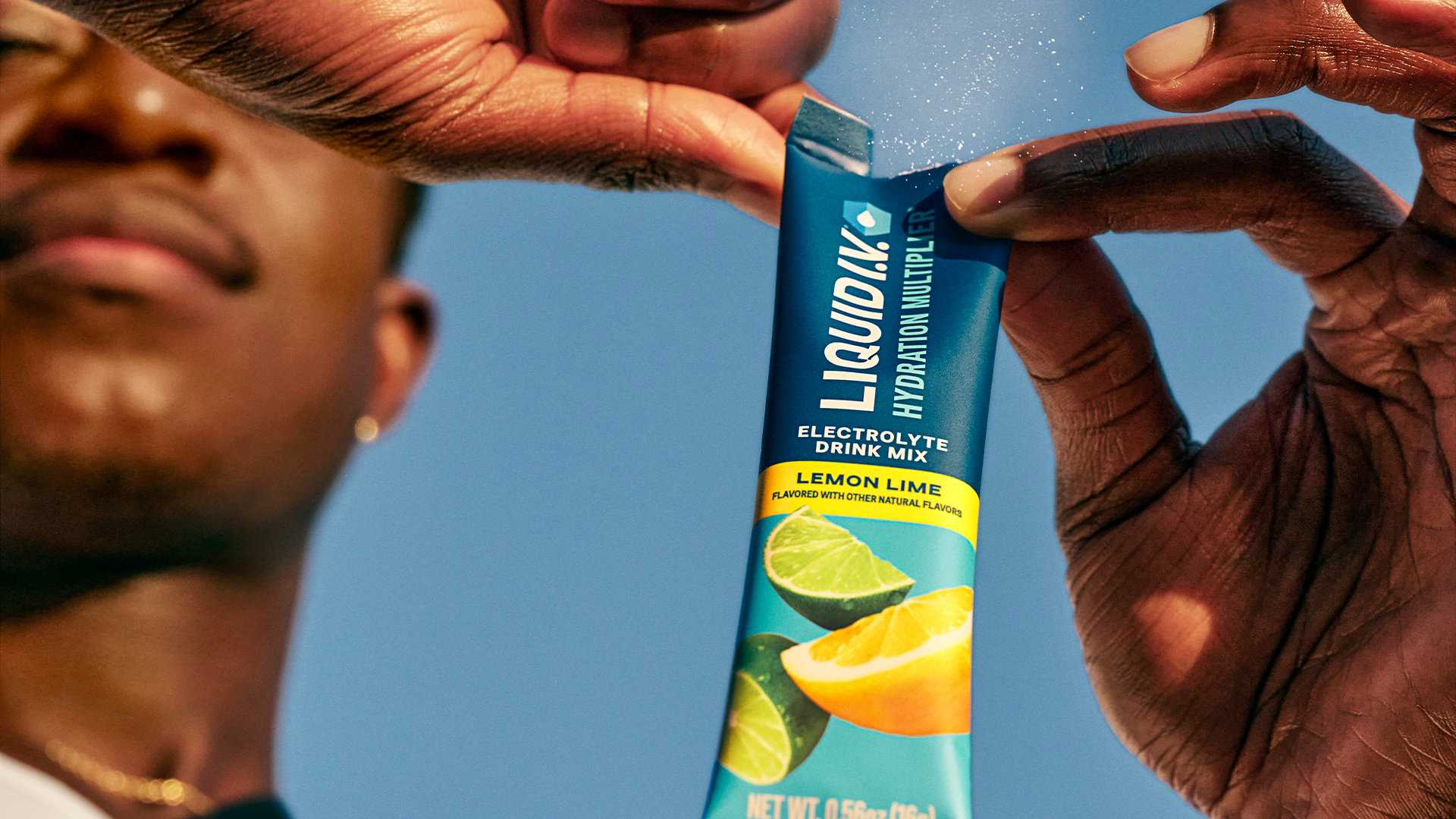 A man opening a packet of Liquid I.V. Electrolyte Drink Mix Lemon Lime.