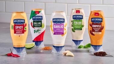 A line-up of Hellmann’s flavoured, squeeze bottle mayo's pictured with key ingredients like limes, chillies, garlic and herbs