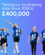 Smiling colleagues in blue charity walk T-shirts taking part in the walk